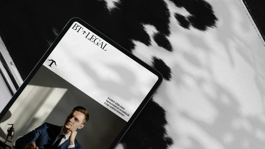 BT Legal arculattervezés: tablet mockup a klasszikus talpas BT Legal logóval, monogrammal és öltönyös férfi fotójával elegáns fekete-fehér környezetben